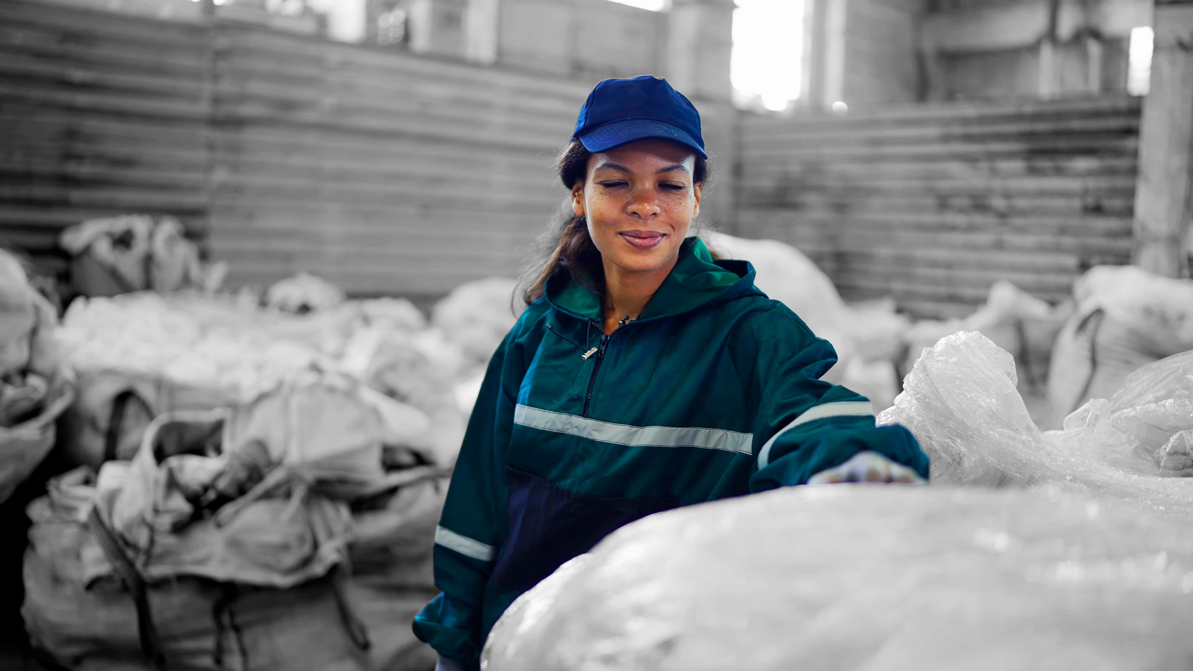 Mujer junto a balas de residuos compactados por la Valpak, mostrando un almacenamiento higiénico y más de 1.4 m³ de volumen por bolsa