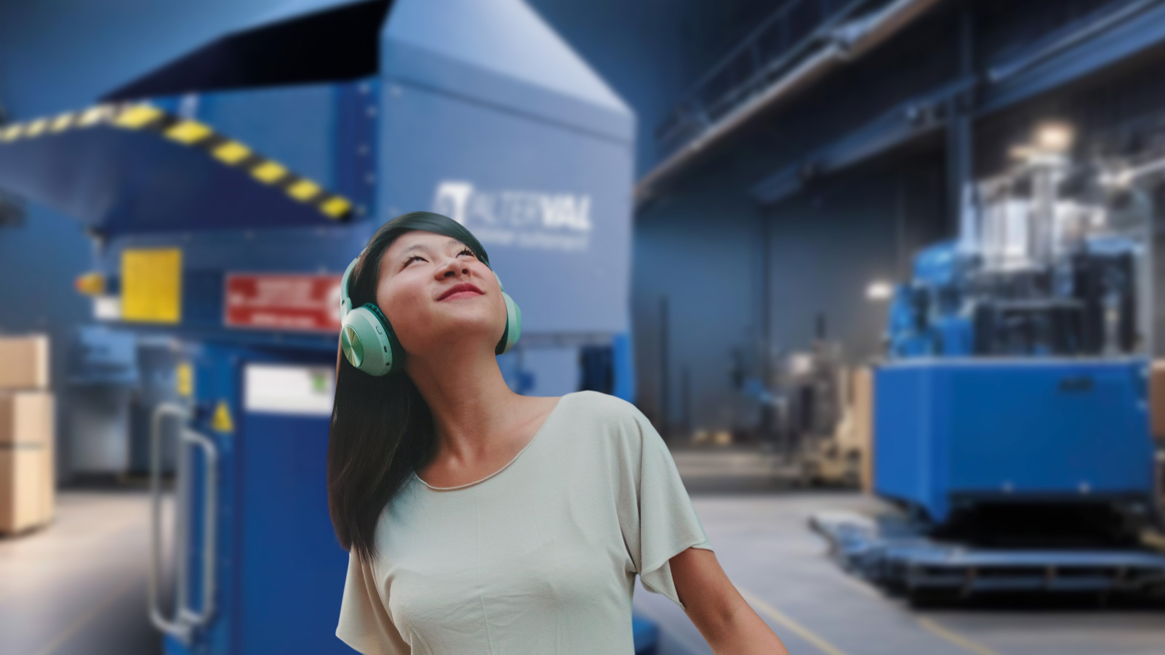 Máquina compactadora Valpak de cartón y plástico funcionando con bajo nivel de ruido mientras una trabajadora escucha música